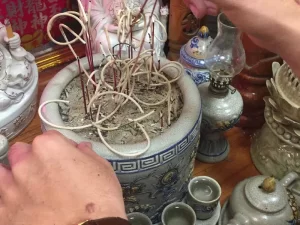 Gia chủ đang rút chân nhang khỏi bàn thờ ông táo cẩn thận